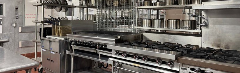 Culiary Department Kitchen Photo of the Culinary Department kitchen featuring several cooking surfaces with pots and utensils stored neatly above.