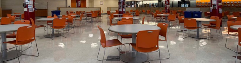 Main cafeteria seating Photo of the student cafeteria seating area with round tables and orange chairs.